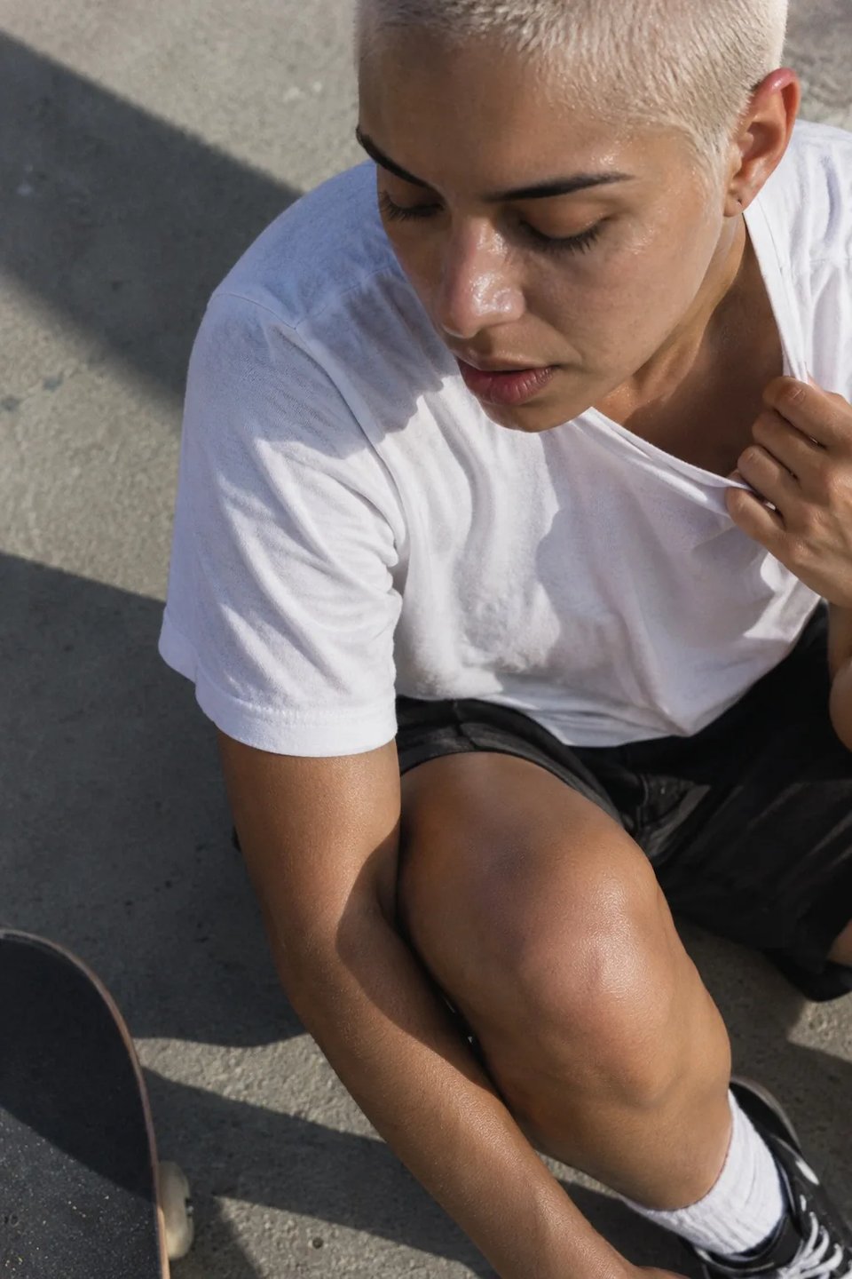 Ein Skater ruht sich nach einer Session auf dem Gehweg aus